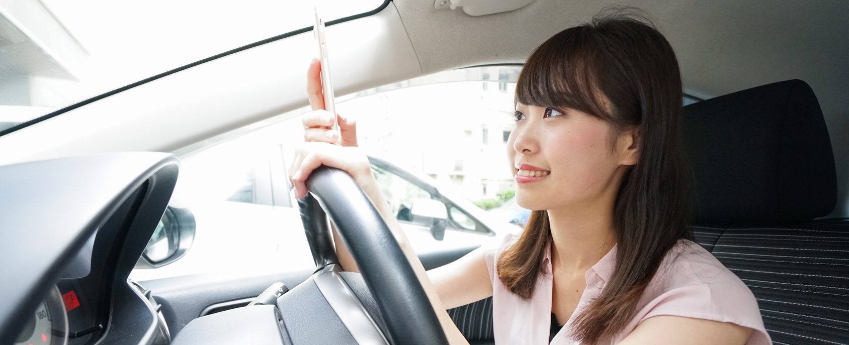Driving woman using smartphone